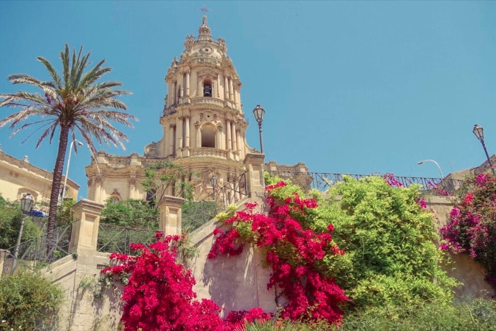 Exterior of San Giorgio Cathedral, showing a view of the church and the surrounding pensile gardens and flowers