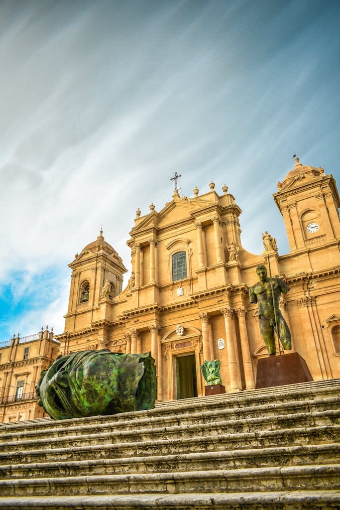 Explore the exquisite facade of Noto Cathedral in Sicily with iconic sculptures and dramatic architecture.