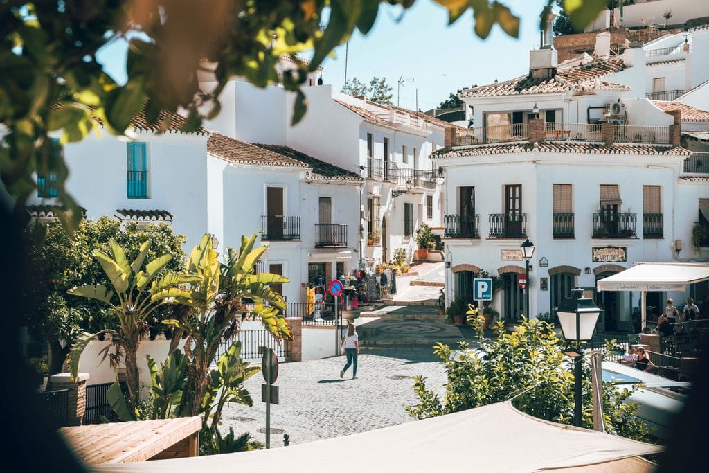Sunny day in Frigiliana, Spain with its iconic whitewashed architecture and vibrant greenery.